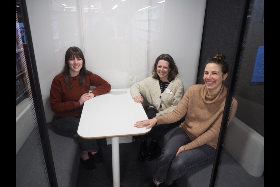 Director of library services, Hilary Bloom (centre), Erika Jaeger beside Bloom and Moriah MacMillan across  from her in a pod. Bloom said that the pods were installed to maximize the use of quiet space and meet a need in the community.