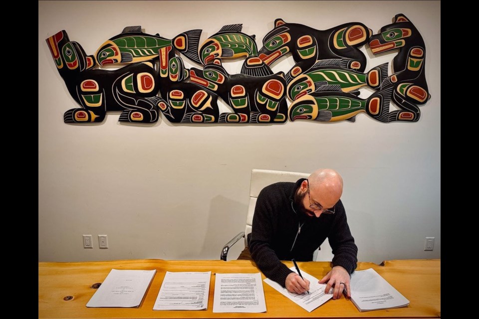 John Matthews, president of Matthews West Ltd, a Squamish-based development company, signs the recent agreement with the City of Port Alberni. 