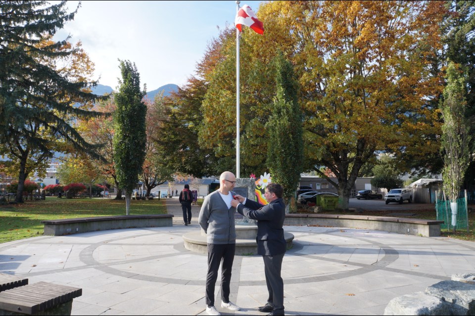 Squamish Legion president Russ Robertson presents the first poppy of the 2023 campaign to Squamish Mayor Armand Hurford on Oct. 23  at Cenotaph Plaza at Stan Clarke Park.                         