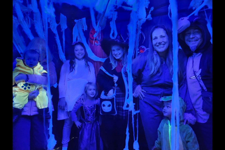 Family fun inside the black tent with the black light and cobwebs at the event on Saturday. L to R; Carol 'Nanny' Gillies, with Olliemay Atleo (10 mos), Rainy A. (11), Posey A. (5), Heather 'Mom' A, Qwyaya A. (2 1/2), & Shawn 'Dad.' 
