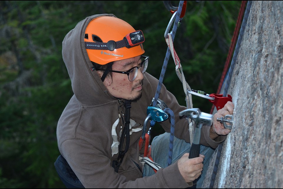 Steven Chua drilling in a new slot for a bolt and hanger on the route The Great Yellow Hope. Steven became a climber while working at The Squamish Chief. 