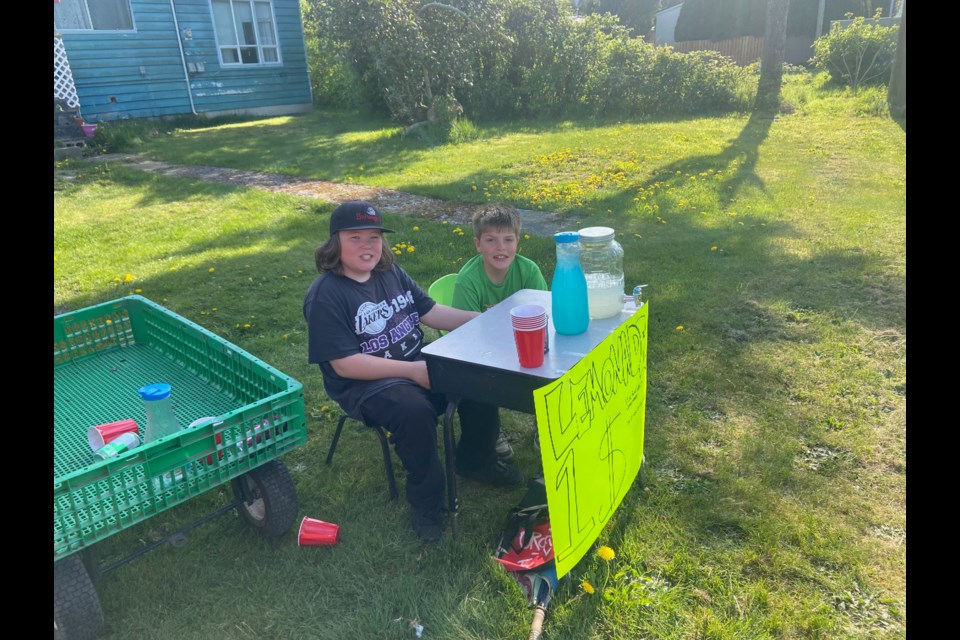 Kory Brooks, 10, and Nathan Quesnel, 12, set up their lemonade stand to earn money for an electric scooter.