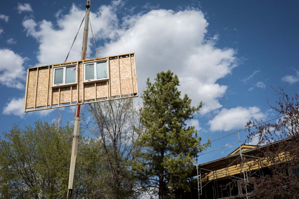 HEAVE HO – Crews hoist a premade wall panel into place during the 2019 retrofit of the Sundance Housing Co-Op. By using premade wall panels, crews were able to renovate the outside of the home without evicting the people living inside it.  PETER AMERONGEN/Photo