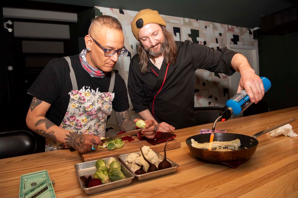 TRADITION MEETS MODERN — First Nations Chef Shane Chartrand (left) prepares a dish that showcases ingredients often used in Indigenous cuisine with the help of Chef Eric Hanson. Featured are smoked salmon, root vegetables, tomatoes, and fish. KEVIN MA/St. Albert Gazette