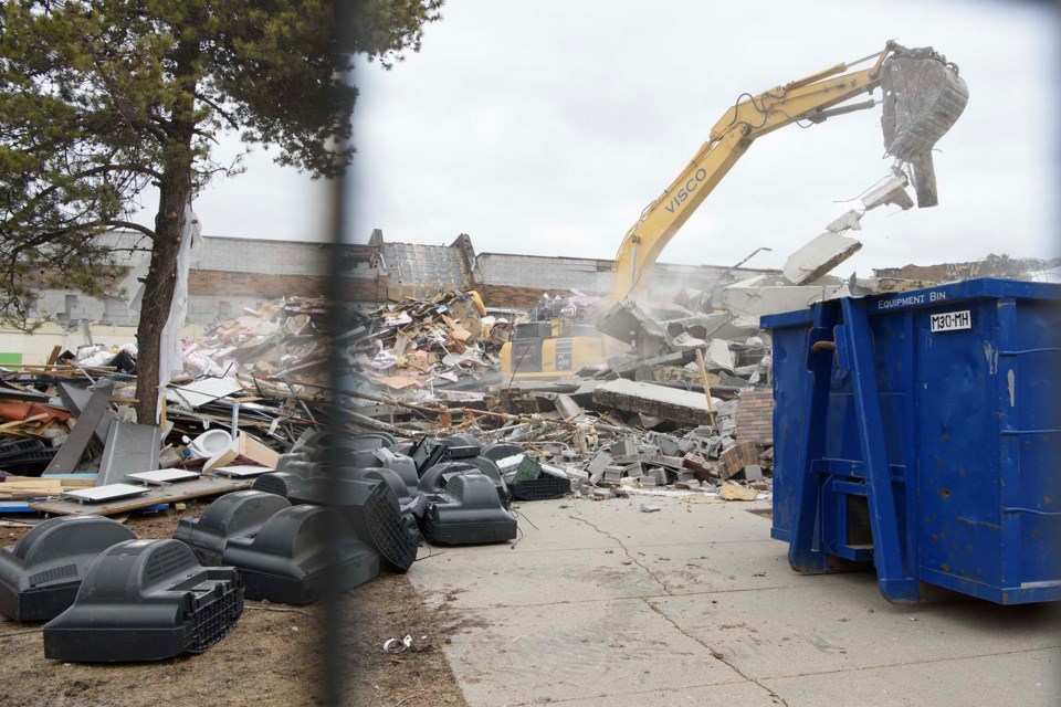 SCHOOL'S OUT FOREVER — A backhoe shifts rubble at the old Paul Kane building. It is shown here atop the site of the school's former front entrance. Major demolition work of the structure started April 19, 2023. KEVIN MA/St. Albert Gazette