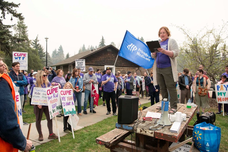 MARSHAL POINT — CUPE Local 1099 president Heidi Hovis stands on a table to address participants of the Waging Ahead Rally on May 11, 2024, as they prepare to set out from the BLESS Summer Nature Centre cabin on St. Albert Trail. About 120 people participated in the rally. KEVIN MA/St. Albert Gazette