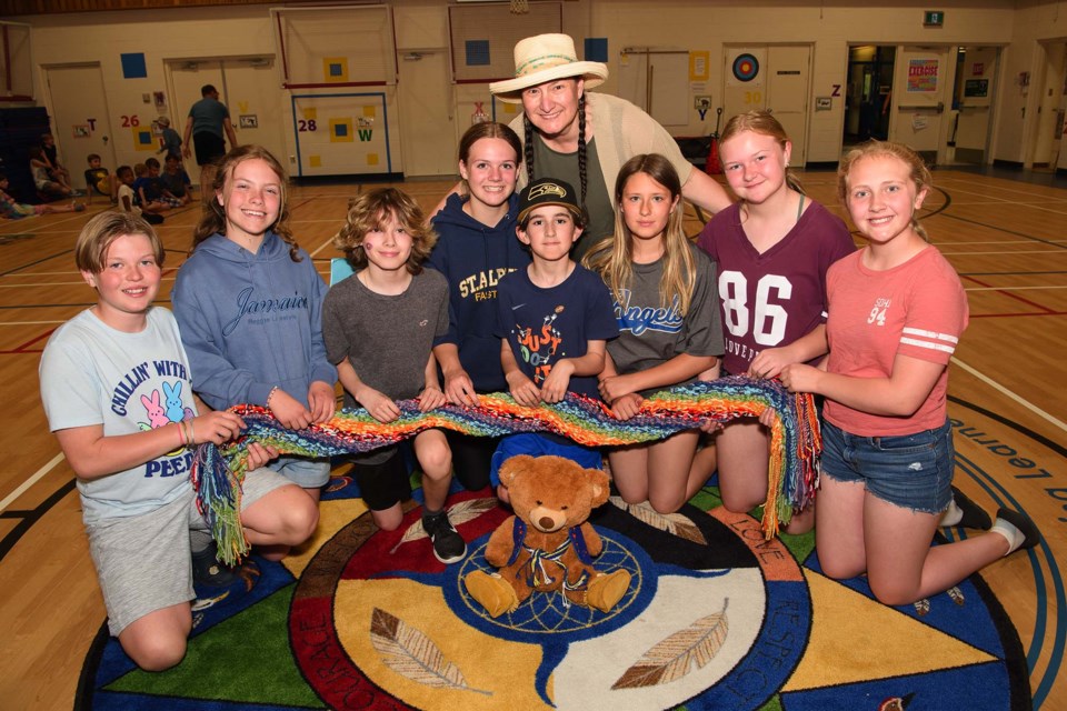 TEAM EFFORT — SAM students show off the Métis sash the entire school created with the help of Celina Loyer (back) to learn about Métis culture. Also shown here is Asiniwaciy, the school's Indigenous am-bear-ssador. KEVIN MA/St. Albert Gazette