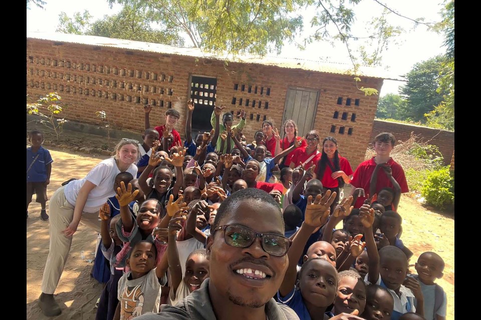 HAPPY TO SEE THEM — Canadian Vision Care volunteers (in red) are greeted by a crowd of patients at the Kande Beach hospital in Malawi. The team helped over a thousand Malawi residents get basic vision care earlier this year. CANADIAN VISION CARE/Photo