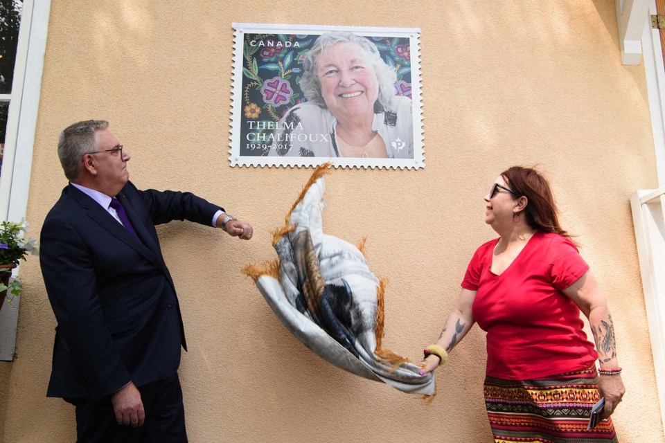 POSTAGE DUE — Sharon Morin (right) and Canada Post president Doug Ettinger reveal an oversized version of a commemorative stamp dedicated to former senator Thelma Chalifoux outside of Juneau House in St. Albert on June 13, 2023. The stamps go on sale June 21. KEVIN MA/St. Albert Gazette