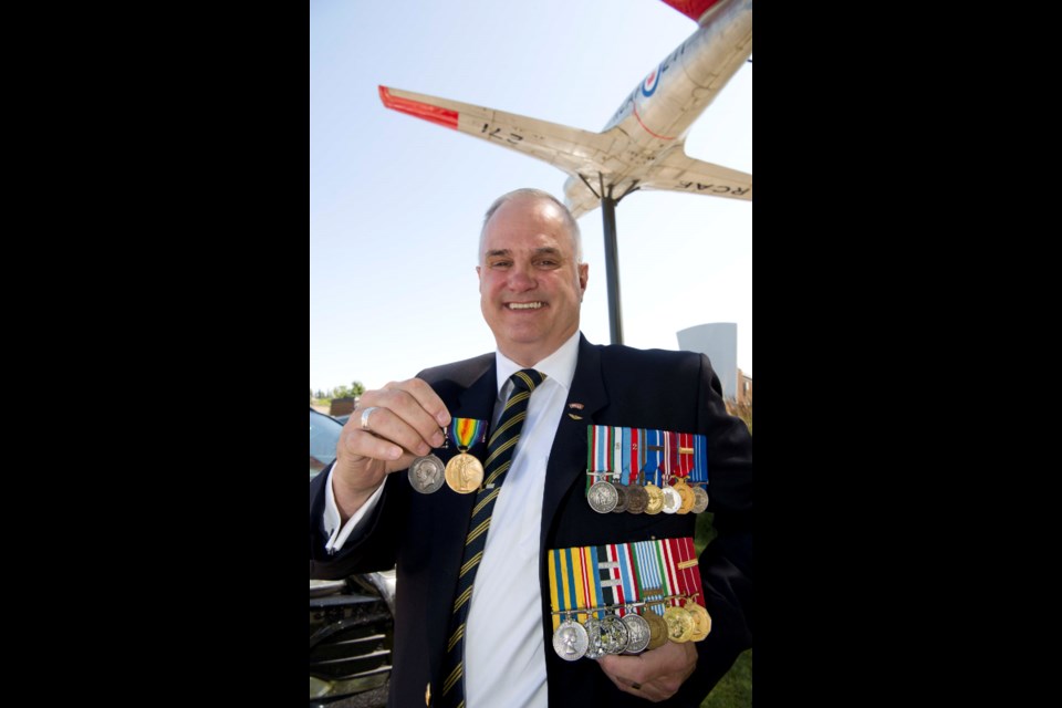 THREE GENERATIONS – Patrick Henneberry holds his grandfather James Patrick's two First World War medals alongside those of his father Leo, who served in the Korean War outside the St. Albert Royal Canadian Legion Hall. He planned to display these alongside his own medals (shown pinned to his chest) and those of his daughter (not shown) to gather four generations of military service in one place. KEVIN MA/St. Albert Gazette