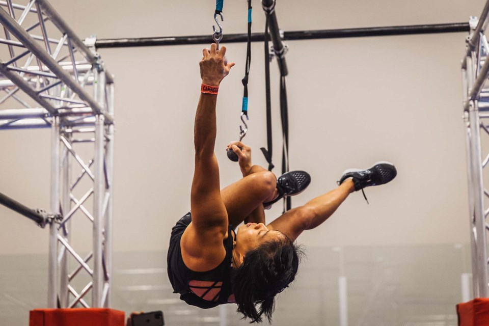 SERIOUS CHALLENGE — Alma Chan tries to traverse a series of ropes by looping a ring onto a hook during the 2022 Canadian Ninja League Nationals.  CANADIAN NINJA LEAGUE/Photo