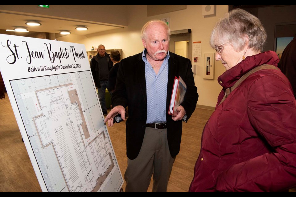 HERE’S THE PLAN — Ron Cust, chair of the St. Jean Baptiste Church building committee, explains the plans for the replacement church to Morinville resident Denise Touchette (in red) at an open house held at the St. Kateri Tekakwitha Academy in Morinville on Nov. 30, 2023. Construction on the new church was set to begin May 21, 2024. KEVIN MA/St. Albert Gazette