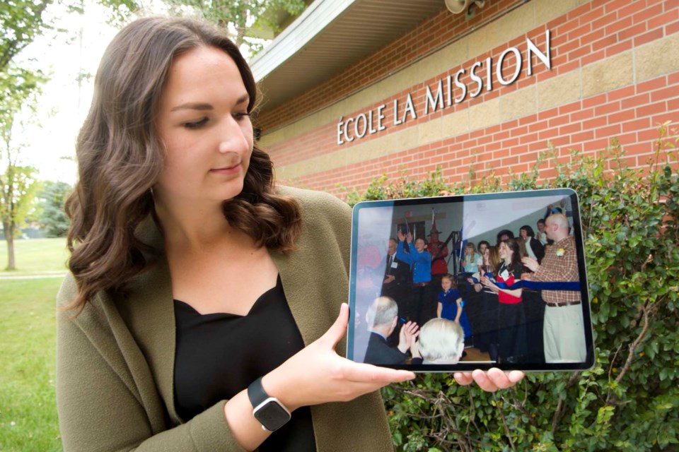 LOOKING BACK – École La Mission teacher Brigitte Burrows looks back at a picture of herself cutting the ribbon at the school's grand opening in March 2004. Burrows started her teaching career this month, and says she hoped to inspire more students to become educators. KEVIN MA/St. Albert Gazette