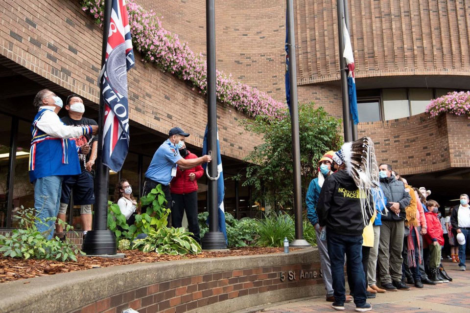 GOING UP — Dignitaries observe the raising of the Treaty 6 and Métis flags at St. Albert Place on Sept. 12, 2021. St. Albert installed two new flagpoles at St. Albert Place this summer so the two flags could be on permanent display. Raising the Treaty 6 flag are Harvey Burnstick of Alexander and St. Albert resident Ryan Arcand. KEVIN MA/St. Albert Gazette