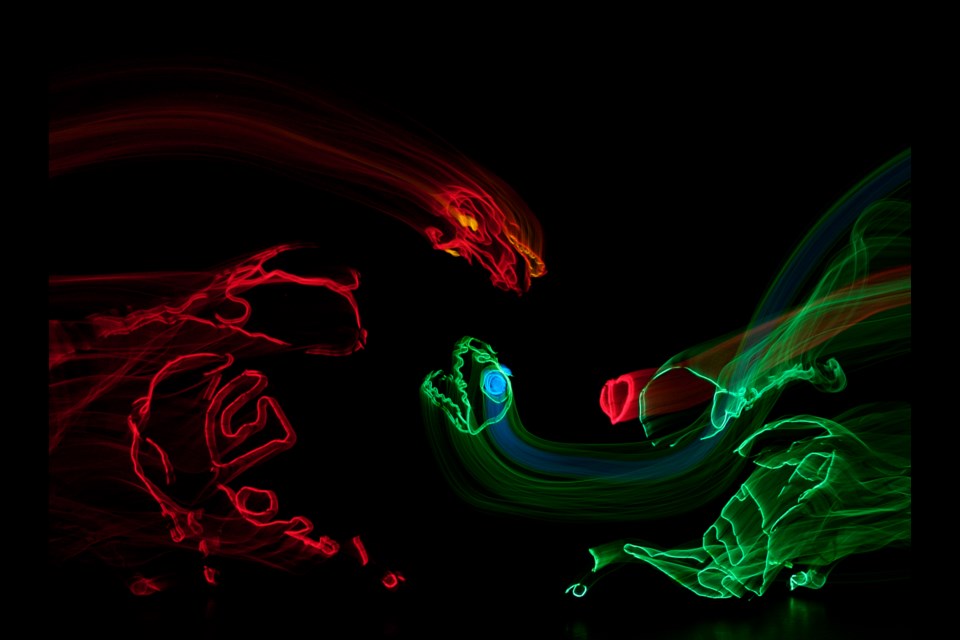 An angry red dragon attacks Dino (green), a young dinosaur on a journey of self-discovery. Dino-Light runs at the International Children's Festival of the Arts from May 30 to June 2.