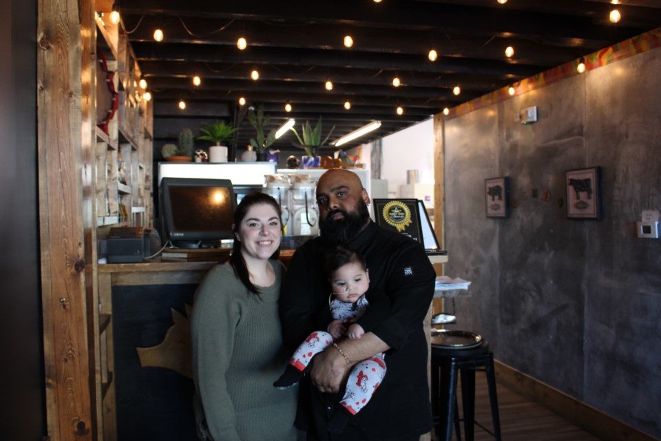 Nicole (left) and Nathan (right) Pratap hold their son Rye in their family owned restaurant, Cerdo Tacos + Tequila.