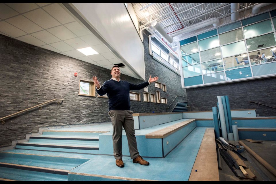 WATERFALL – Four Winds Principal Dan Requa shows off the agora/main stairwell of Four Winds Public School. The stairs are meant to resemble a mountainside waterfall.   DAN RIEDLHUBER/St. Albert Gazette 