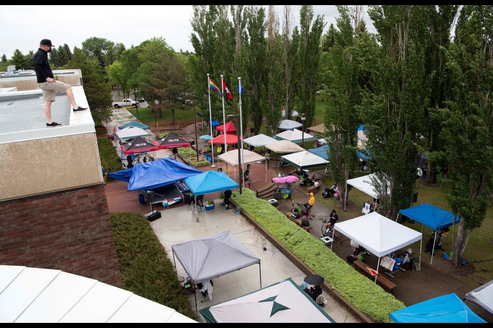 RAISING ROOFS — Bellerose teacher Mike Larocque observes the forest of tents and tarps erected during the 2021 Bellerose Bikeathon, which took place amidst pouring rain, driving wind, and the COVID-19 pandemic. KEVIN MA/St. Albert Gazette