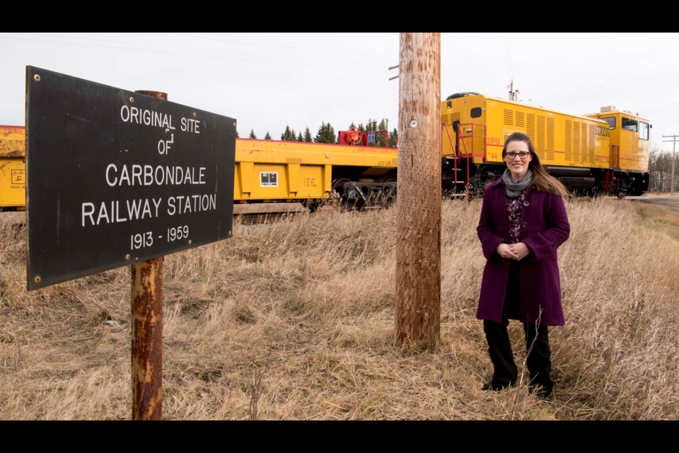 HISTORIC SITE – Carbondale resident Shannyn Rus stands near a marker that indicates how the Carbondale Rail Station once stood near her Sturgeon County home. The station was destroyed in a train crash 60 years ago this month. KEVIN MA/St. Albert Gazette