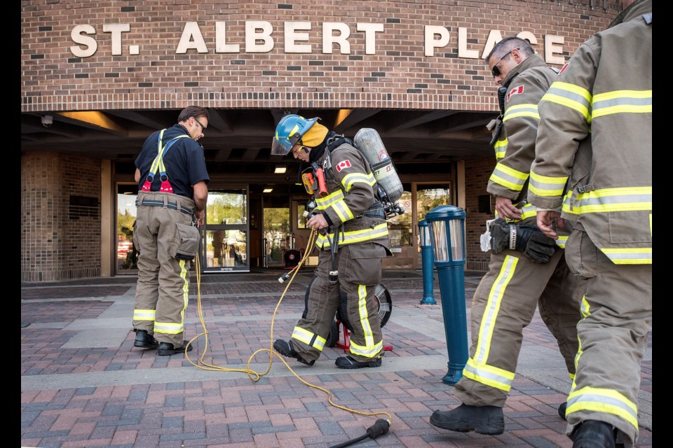 Firefighters were called to St. Albert Place at around 5:15 p.m. Aug. 22 after city manager Kevin Scoble smelled what was initially reported as ammonia in the front stairwell. (The actual source of the smell has yet to be identified.) Here, firefighters run power cords to ventilation fans used to clear the air from the stairwell. DAN RIEDLHUBER/St. Albert Gazette