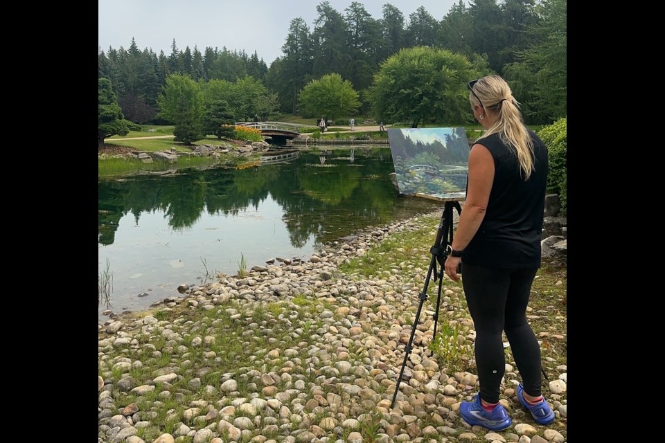 Alberta Artist-in-Residence Samantha Williams-Chapelsky paints the University Botanic Park bridge.