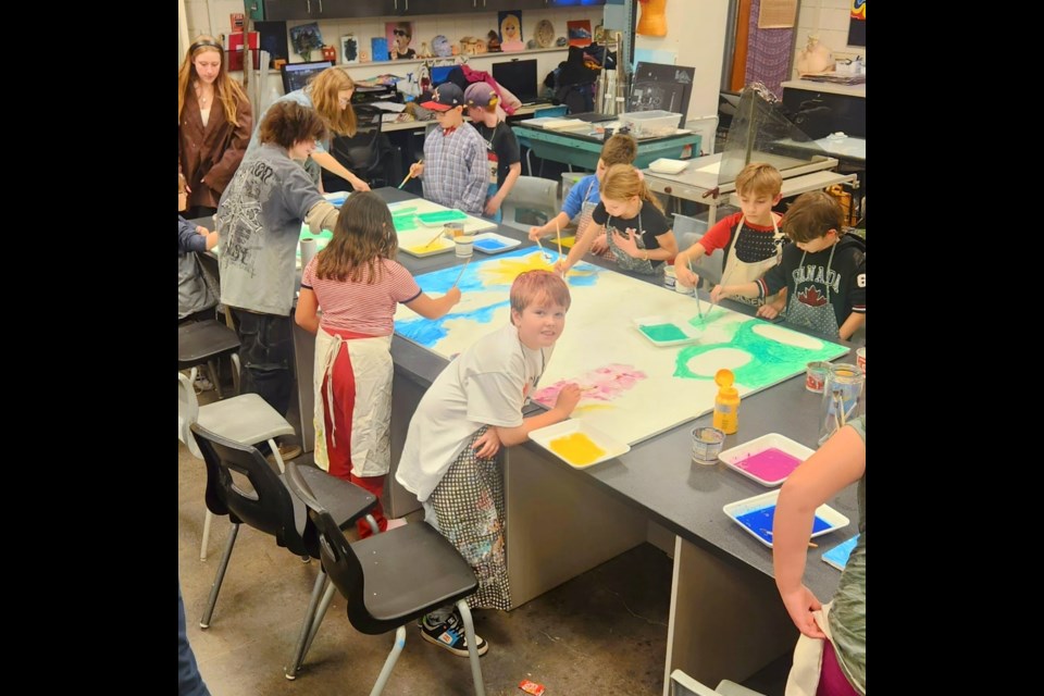Muriel Martin's Grade 4 class and Bellerose's Grade 11 IB art students work together under-painting the mural. SUPPLIED/Photo