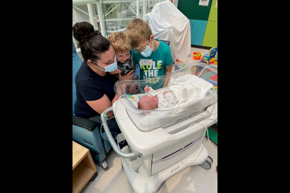 It wasn't until July 2021 - seven months after he was born - that his brothers Jacob (center) and Liam (right) met Benjamin.