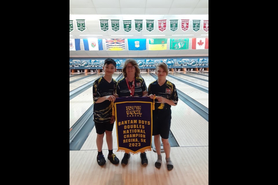 Lucas Mak, Denise Howie, and Ethan Rosborough pose with their championship banner after winning the Youth Bowl Canada National Championships in Regina. St. Albert Bowling Centre/ SUPPLIED