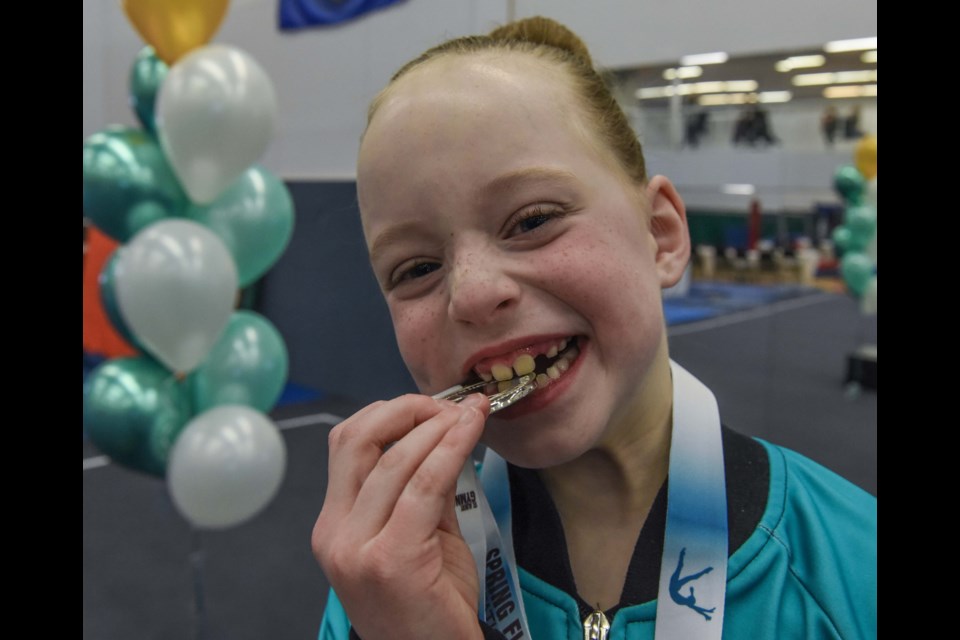 Eight-year-old Callie Jenkins from the St. Albert Gymnastics Club, shows off the silver medal she won on the beam during the Spring Flip Invitational Competition at the St. Albert Gymnastics Club in St Albert on Saturday March 11, 2023. ( All photos by JOHN LUCAS/St Albert Gazette)