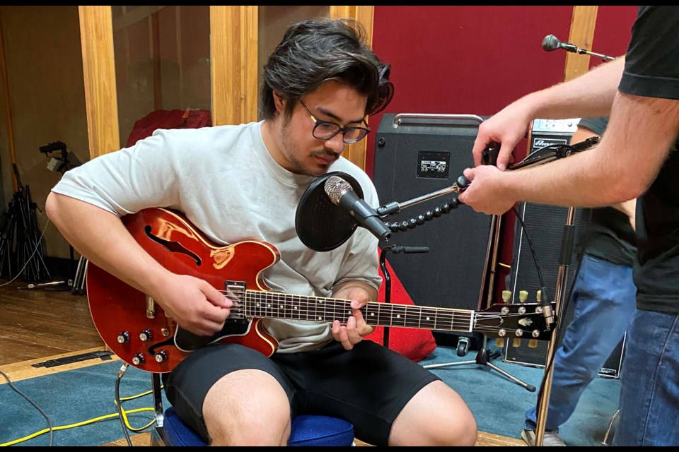 Evan Salcedo  tunes his guitar at the Audio Department in preparation to record, Free, an acoustic pop song that is part of Amplify's deubt album. KATHLEEN BELL