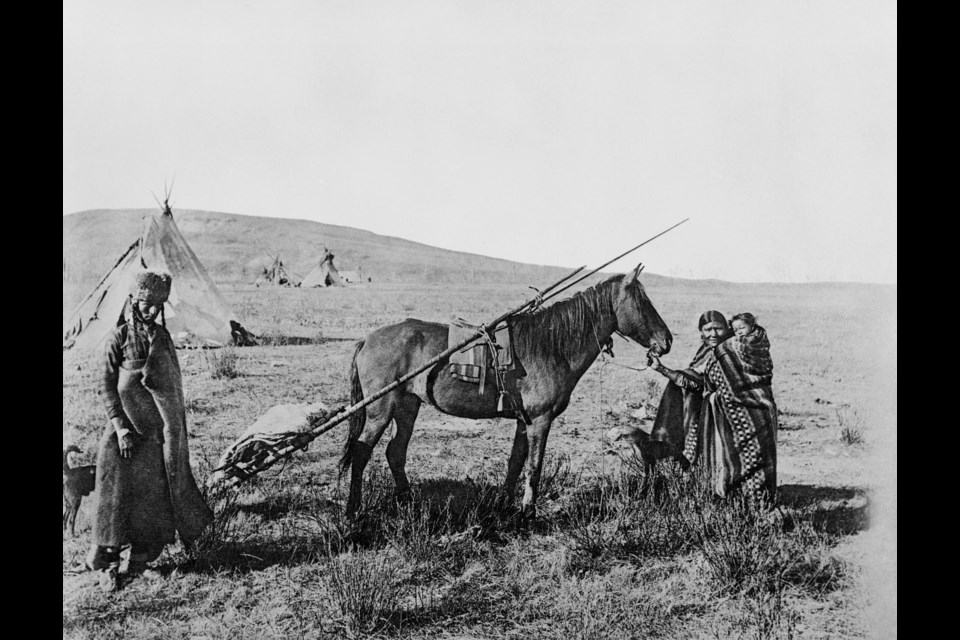 A Cree family in 1880, readies for a journey strapping their belongings to a horse-drawn travois. UNIVERSITY OF CALGARY, GLENBOW WESTERN RESEARCH COLLECTION 