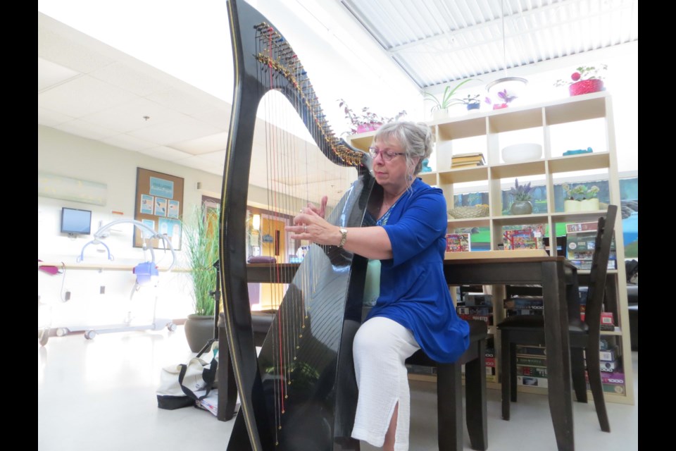 Cheryl Dalmer, a certified harp therapist practitioner, plays the string instrument for Foyer Lacombe residents in hospice care. ANNA BOROWIECKI/St. Albert Gazette 