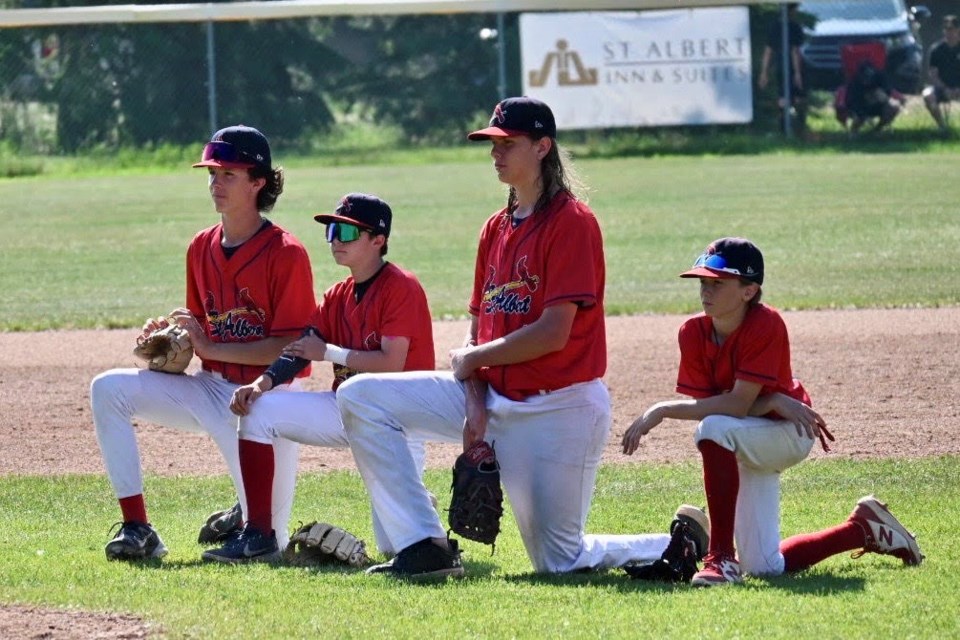 U15 AAA Cardinals players Tyler Diprose, Lincoln Aubin, Matt Willmets, and Jacob Fystro take a knee in the infield prior to a game at Legion Memorial Ball Park JASON WILLMETS/Photo