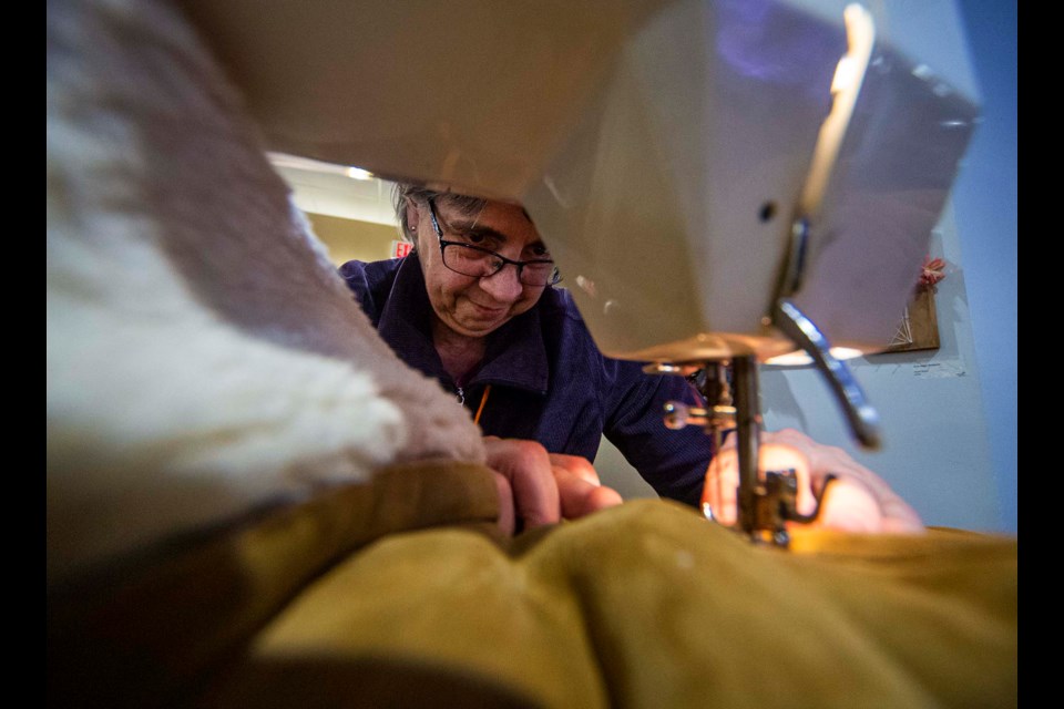 SEAMSTRESS – Volunteer sewer Gisele Gobeil uses a sewing machine to repair a torn winter coat during a Fix-It Café event at the Revera River Ridge Retirement Residence in December 2019. Gobeil said she learned to sew from her grandmother and enjoys helping others with her skills.  CHRIS COLBOURNE/St. Albert Gazette