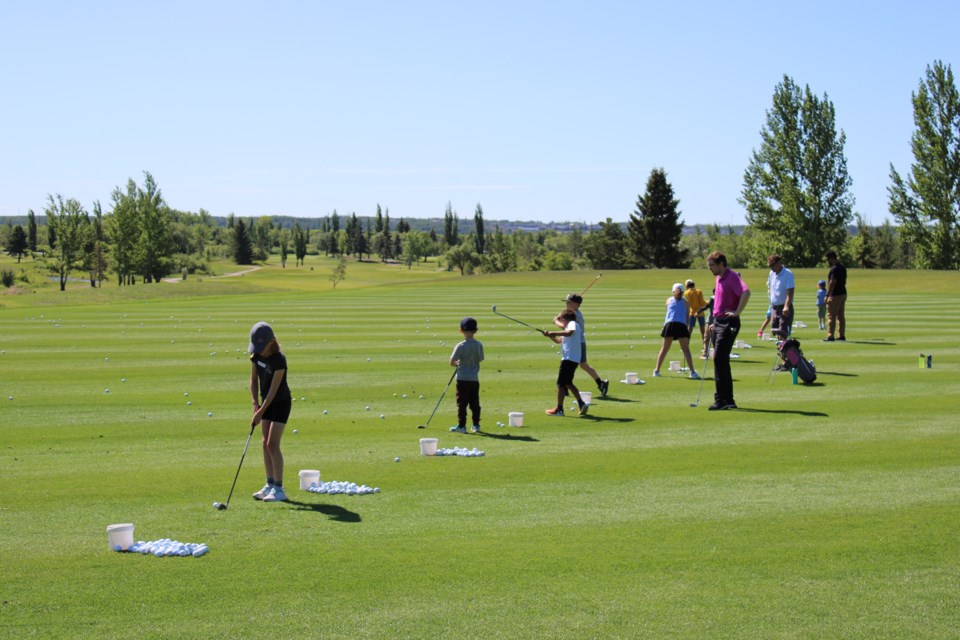 Children during their first golf lesson at the Sandpiper Golf and Country Club summer camps from June 30 to July 3. They are practicing hitting the golf balls. 