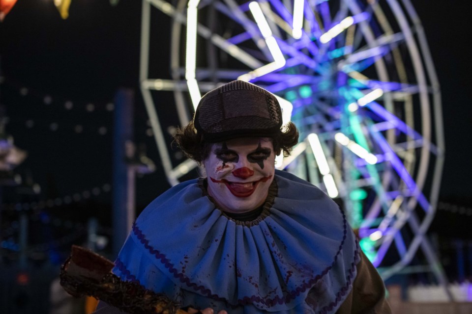 A killer clown ghoulishly stalks his victims during DARK, Fort Edmonton's Halloween experience.