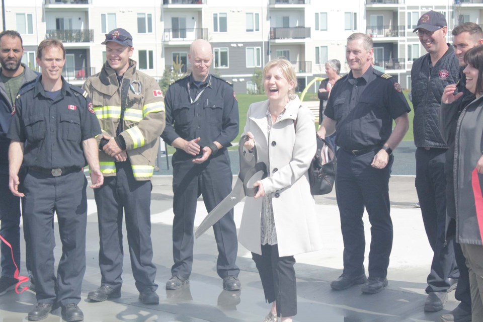 Deputy Mayor Shelley Biermanski laughs with a fire crew from Fire Hall #3 after cutting the ribbon at the grand-opening of St. Albert's new splash pad. JACK FARRELL/St. Albert Gazette