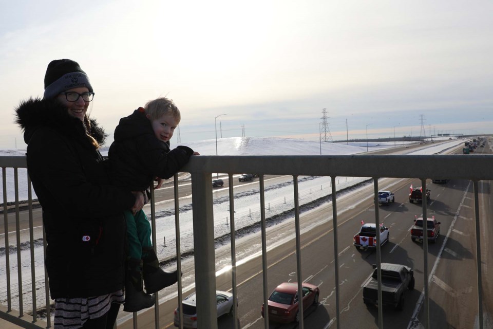 Courtney and Jack vanVeen stand on the St. Albert Trail overpass as a convoy of protestors honks along Anthony Henday Drive on Saturday. JESSICA NELSON/St. Albert Gazette