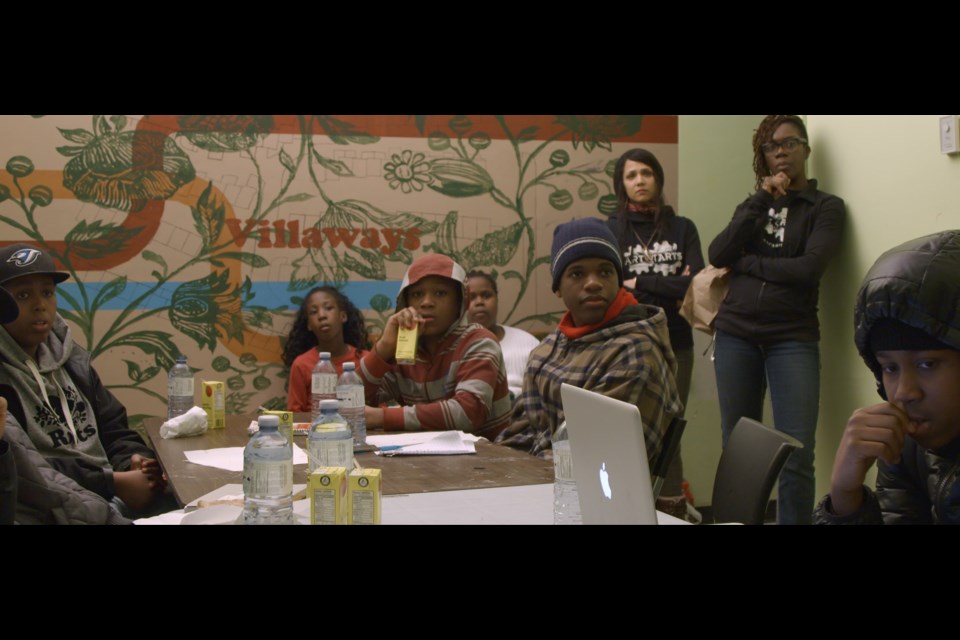 A scene from Unarmed Verses, showing kids from the Villaways community participating in the Art Starts music program.