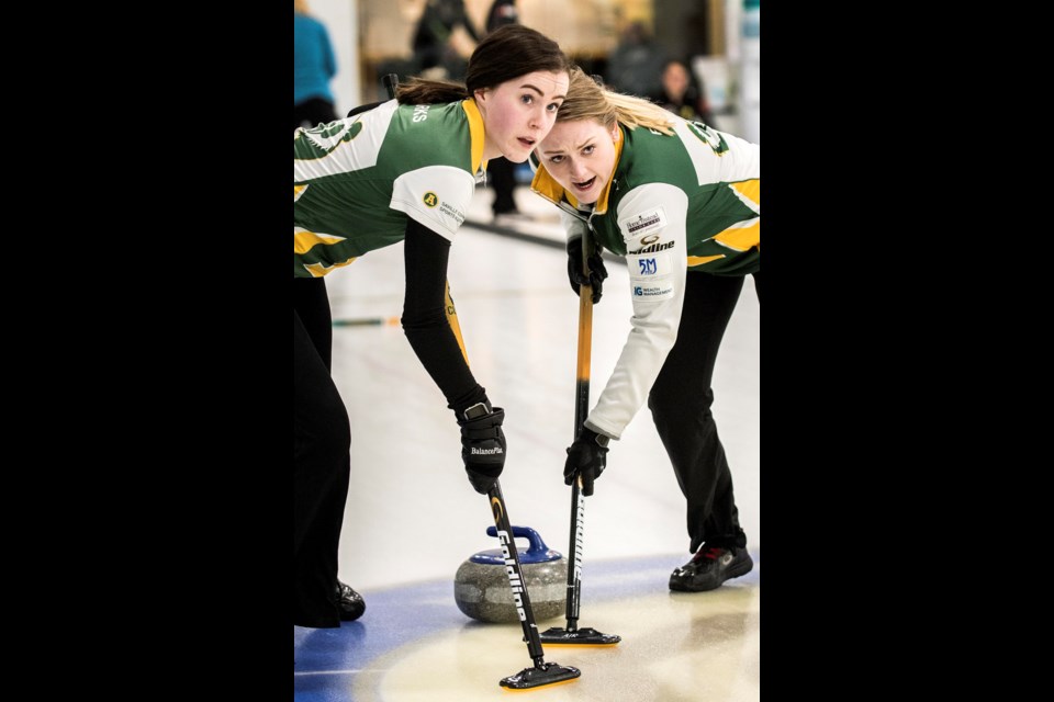 SWEEPING TO VICTORY – Abby Marks, left, of St. Albert and Paige Papley drag a rock for Team Sturmay of the University of Alberta Pandas at the Alberta Junior Curling Tour’s Players Championship last weekend at St. Albert Curling Club. The U21 national champions and world silver medallists, with Selena Sturmay as skip, Marks at third, Kate Goodhelpsen at second and Papley as lead, beat Kayla Skrlik of the Glencoe Club of Calgary 5-4 in Sunday’s final. The Saville Centre rink produced the winning point in the eighth end for its fifth consecutive victory in the six-team women’s competition after losing the opening draw 7-5 to Zoe Cinnamon of Cochrane. Skrlik was the A qualifier and Sturmay won the B qualifier 8-6 against Cinnamon’s U18 lineup. The semifinal was 8-1 in six ends for Sturmay against Cinnamon. Sturmay and Skrlik were ranked first and second, respectively, on the provincial U21 junior tour. The two rinks also clashed in the U21 provincial final as Sturmay counted one in eight and stole deuces in nine and 10 for the 7-6 championship victory.  