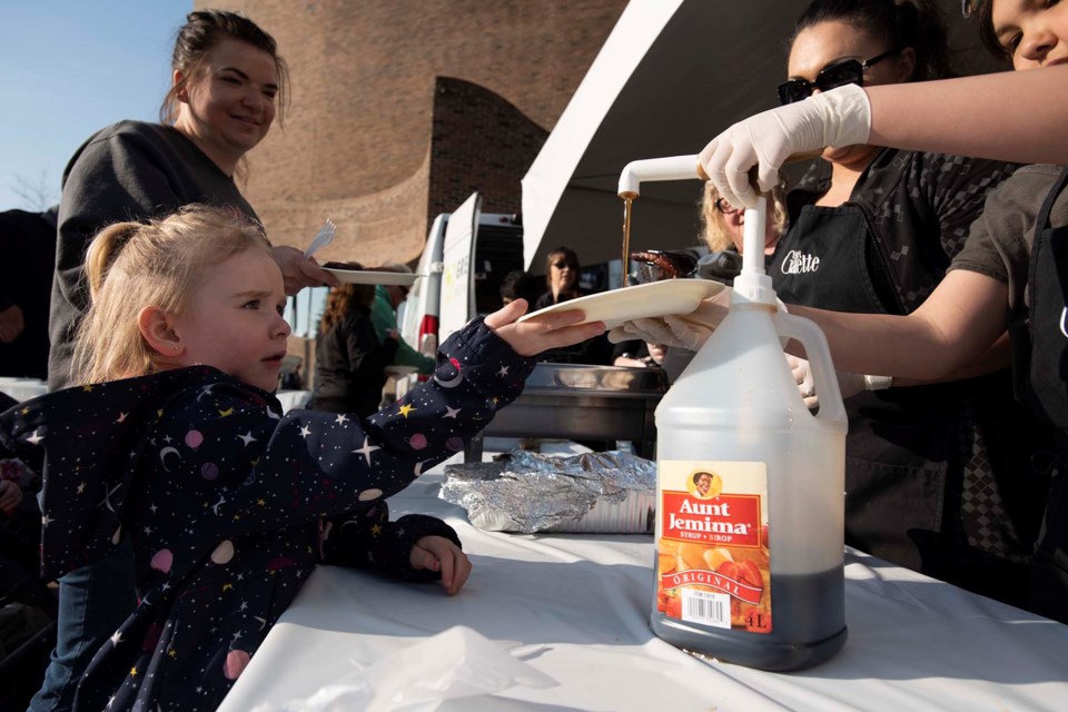 Four-year-old Macy Sowers gets syrup for her pancakes as her mom Ciara Sowers, left, waits her turn during The Gazette's annual Rainmaker Pancake Breakfast at St. Albert Place May 25, 2019. FILE PHOTO/St. Albert Gazette