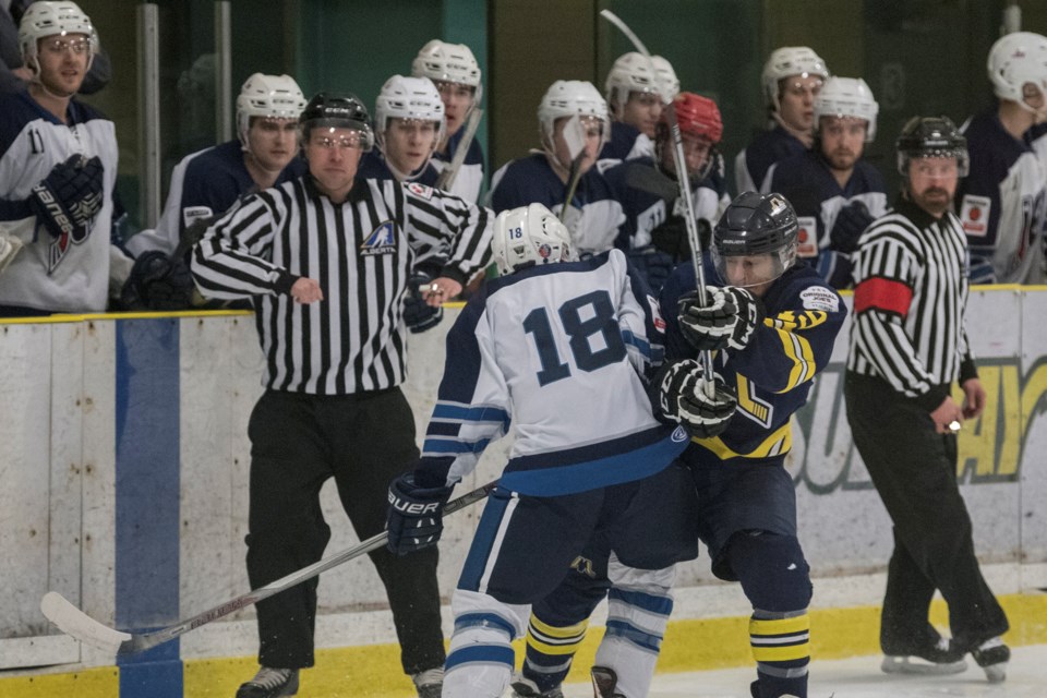 SUDDEN IMPACT – Sheldon McCoy, left, of the Morinville Jets and Marco Runco of the St. Albert Merchants collide in front of the Morinville bench in Friday's junior B match at Jarome Iginla Arena. Watching the play unfold is linesman Connor Watt and referee James Armistead, who were working the rivalry game with linesman Keith Beaudin. The somewhat tame affair penalty-wise ended with the Merchants winning 7-0. JOHN LUCAS/St. Albert Gazette