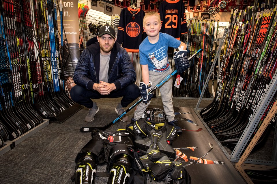 GEARED UP FOR HOCKEY – Leon Draisaitl of the Edmonton Oilers joined Mercer Fink of Red Deer at St. Albert Source for Sports to assist the eight-year-old, with the novice B Red Deer Nighthawks, choose $1,000 worth of hockey equipment on Thursday. Kentwood Ford, Team Ford and St. Albert Source for Sports partnered together to donate the equipment to the winner of a write-in contest explaining the need for the equipment.
DAN RIEDLHUBER/St. Albert Gazette