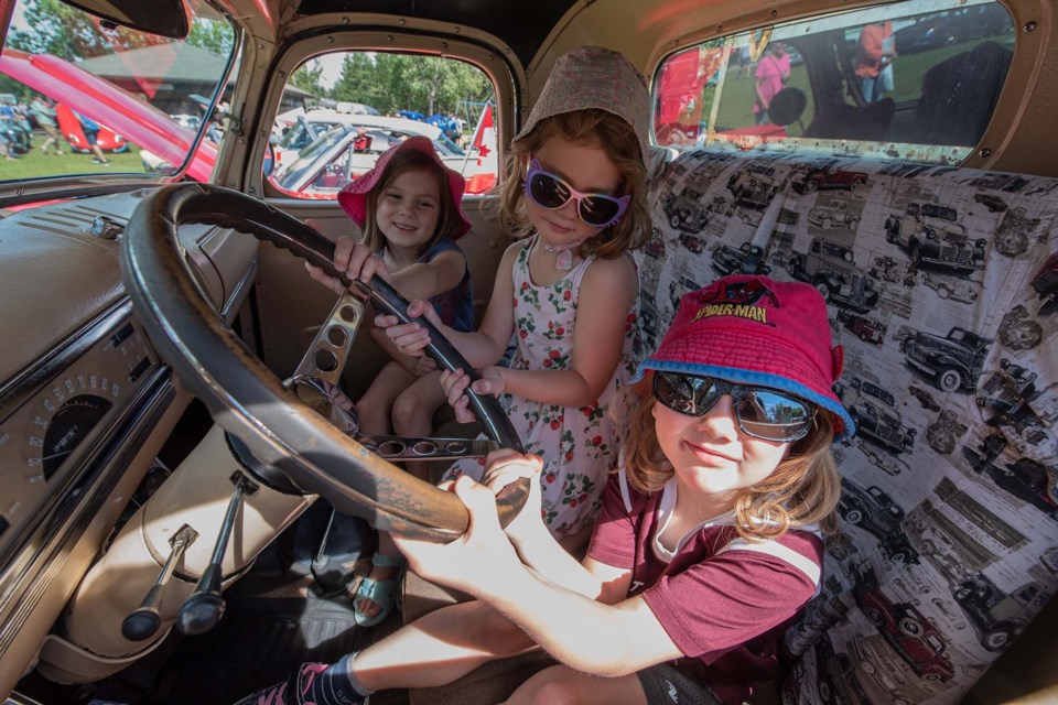 Sisters Petranella, 4, Natanya, 6, and Odelia Darnhoorn, 4, sit in the driver's seat of Tim Streisel's 1941 Chevy pickup at the Rock'n August Show and Shine in St. Albert on Saturday, Aug. 6, 2022. JOHN LUCAS/St. Albert Gazette