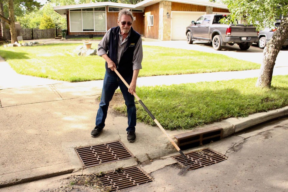 Art Dack stands in front of four drainage grates at the end of his driveway. Every time it rains Dack is forced to head outside with a rake and his rubber boots to clear the debris so water can drain instead of backing up onto his driveway. JENNIFER HENDERSON/St. Albert Gazette