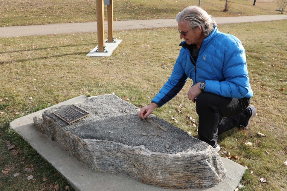 Jim Hole examines the spot where the missing bronze sculpture once sat on Nov. 5, 2021 at Ted Hole Park. JESSICA NELSON/St. Albert Gazette