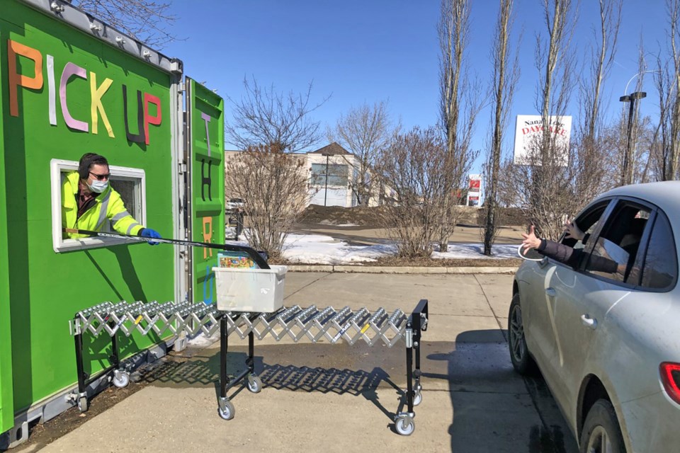 Mission Fun and Games owner John Engel pushes a box of board games to a customer waiting at the drive-thru service. BRITTANY GERVAIS/St. Albert Gazette