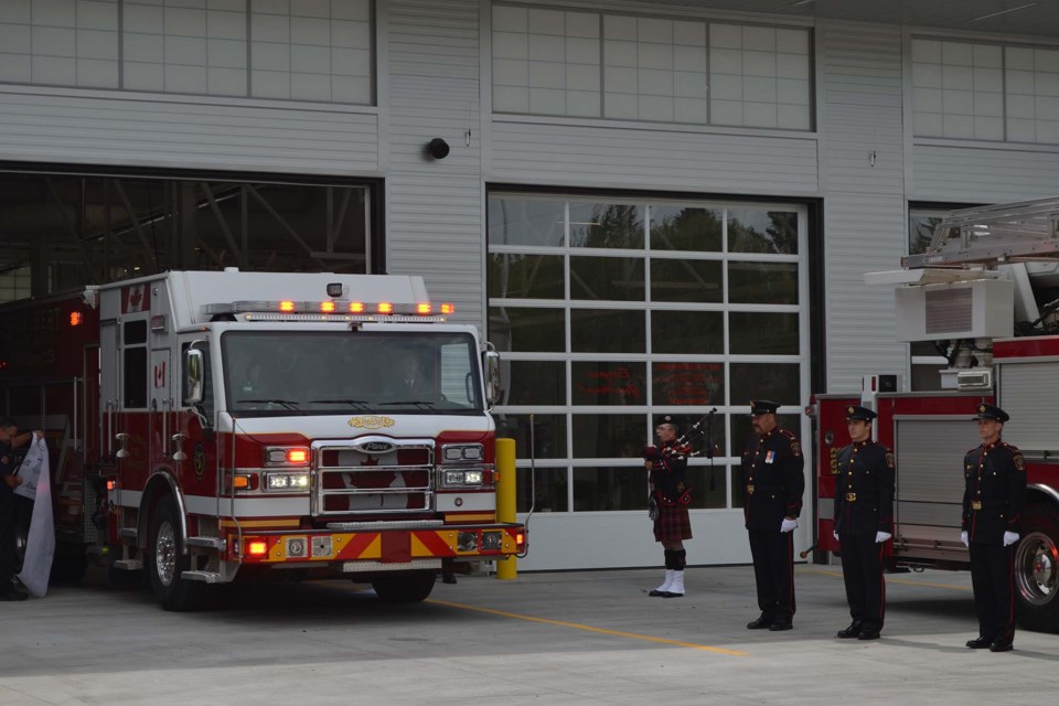 Mayor Cathy Heron and Municipal Affairs Minister Ric McIver ride up-front in a fire truck to drive through a ribbon marking the opening of the new Station #1 on June 8, 2022. RACHEL NARVEY/St. Albert Gazette