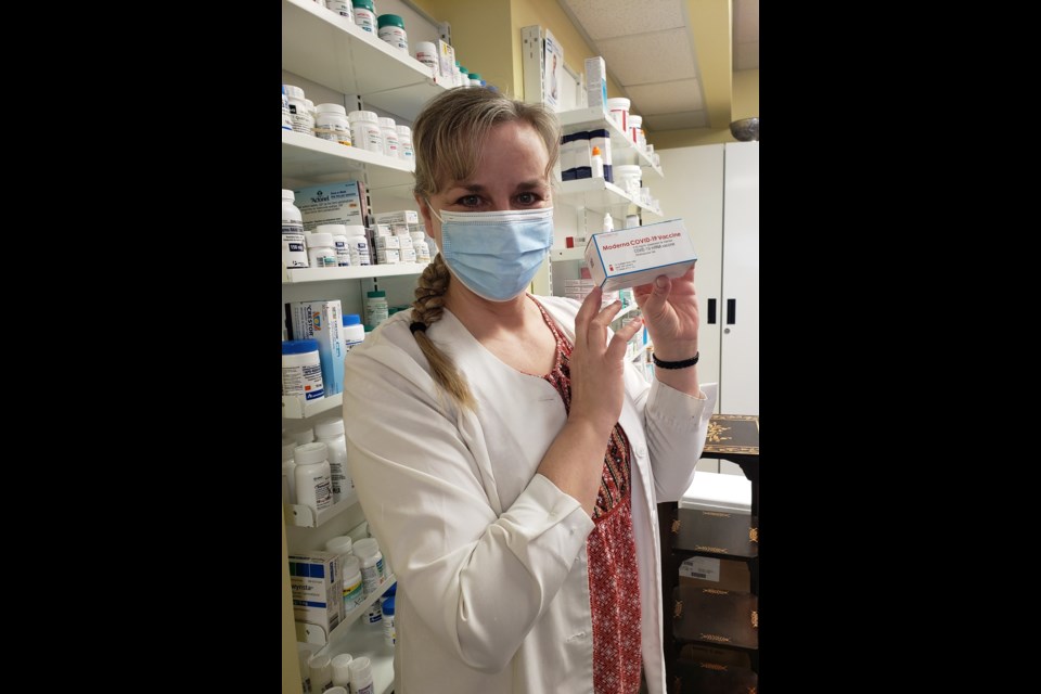 Midtown Apothecary's Karen Moak is smiling under that mask. She's holding up a box containing one Moderna COVID-19 vaccine, which the St. Thomas Street drug store started to administer on Monday morning as part of Phase 2a of the province's pandemic response.