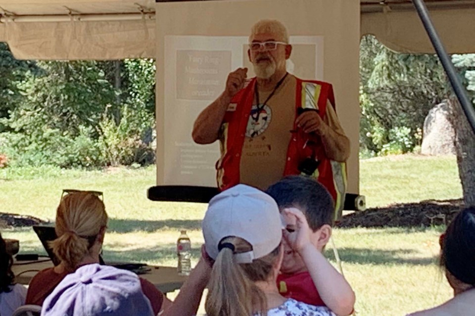 Martin Osis, standing in the high-visibility vest, gives a presentation during the Mushroom Expo to a crowd of eager mycophiles looking to learn more about common edible and medicinal mushrooms on Aug. 14, 2022. JACK FARRELL/St. Albert Gazette